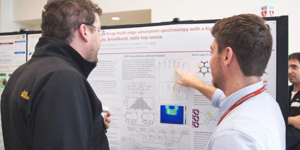 two researchers reviewing scientific poster