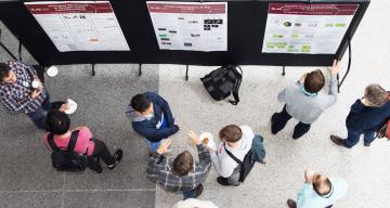 researchers presenting posters to attendees